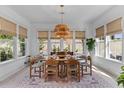 Bright dining room with a rustic chandelier, large windows, and seating for six at 137 Low Tide Ct, Charleston, SC 29492