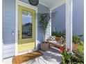 Inviting front porch with a bright yellow door, bench, and potted plants at 137 Low Tide Ct, Charleston, SC 29492