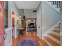 Home foyer with hardwood floors, a staircase, and views into the living room with fireplace and a half-bathroom at 1391 Southlake Dr, Mount Pleasant, SC 29464