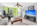 Bright living room with a comfortable sofa, coffee table, an entertainment center with a large television, and a window view at 1516 Mandarin Ct, Summerville, SC 29483