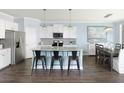 Modern kitchen with stainless steel appliances, island seating, and an adjacent dining area at 154 Royal Cainhoy Way, Huger, SC 29450
