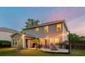 Inviting backyard patio with string lights, outdoor seating, fire pit, and privacy fence perfect for entertaining at 1606 Stovall Ct, Johns Island, SC 29455