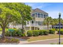 Beautiful exterior view of a two-story townhome featuring manicured landscaping, mature trees, and a private entrance at 1650 Long Grove Dr, Mount Pleasant, SC 29464