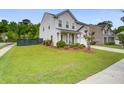Well-manicured lawn surrounds this home with vinyl siding and a two-car garage at 1901 Toland Ct, Johns Island, SC 29455