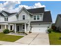 Charming two-story home with a metal roof and a well-manicured front yard with an attached garage at 206 Evergreen Ave, Summerville, SC 29485