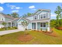 Inviting two-story home with a manicured lawn, complemented by charming landscaping at 208 Cherry Grove Dr, Summerville, SC 29483