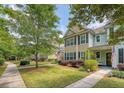 Townhome exterior featuring a well-kept lawn, mature trees, and a welcoming walkway at 2096 Promenade Ct, Mount Pleasant, SC 29466