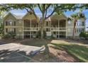 Two story condo building with dual entry points with front yard featuring a large tree and palm tree at 2134 Landfall Way, Seabrook Island, SC 29455