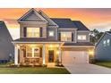 Inviting two-story home showcasing a brick and gray facade, well-manicured lawn, and a charming front porch at 214 Squire Pope Rd, Summerville, SC 29486