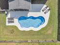 An aerial view of a kidney-shaped pool with a white concrete surround, lounge chairs, and a well-kept lawn at 214 Squire Pope Rd, Summerville, SC 29486