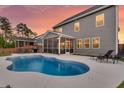 An outdoor pool with lounge chairs and a screened porch attached to a two-story house at 214 Squire Pope Rd, Summerville, SC 29486