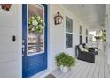 Inviting front porch with a blue door and wreath, complemented by comfortable seating and decorative accents at 2194 Cultura Cir, Mount Pleasant, SC 29466
