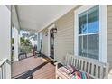 Inviting front porch with rocking chairs, a bench, and a decorative wreath on the front door at 2636 Colonel Harrison Dr, Johns Island, SC 29455