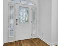 Stylish front door with decorative glass, side windows, and white trim, complements the hardwood floors at 30 Yacht Harbor Ct, Isle of Palms, SC 29451