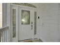 Elegant front door with decorative glass, side windows, and white trim, creating a welcoming entrance at 30 Yacht Harbor Ct, Isle of Palms, SC 29451