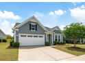 Attractive home features a two-car garage, lovely landscaping, and neutral gray siding at 3061 Cross Vine Ln, Summerville, SC 29483