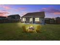 Relaxing backyard featuring a stone fire pit and screened-in patio at 312 Cypress Branch Rd, Huger, SC 29450
