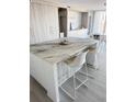 Kitchen island featuring a unique marble countertop and modern white bar stools at 330 Concord St # 5D & 5E, Charleston, SC 29401