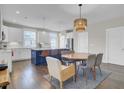 Open-concept kitchen and dining area with a large island, modern lighting, and hardwood floors at 3990 Hillyard St, North Charleston, SC 29405