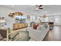 Bright living room features a ceiling fan, lots of seating, and access to the kitchen and dining area at 3990 Hillyard St, North Charleston, SC 29405