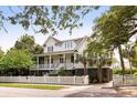 Inviting two-story home with a front porch, white picket fence and lush landscaping at 407 Pitt St, Mount Pleasant, SC 29464