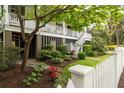 Beautifully landscaped front yard with mature trees and colorful flower beds at 407 Pitt St, Mount Pleasant, SC 29464