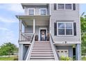 Inviting front entrance with a charming door wreath, potted plants, and elevated porch at 482 Sanders Farm Ln, Wando, SC 29492