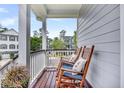 Relaxing porch featuring rocking chairs with cushions and decorative pillows overlooking neighborhood at 482 Sanders Farm Ln, Wando, SC 29492