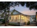 Charming one-story home featuring a cozy porch with railings, landscaped yard, and a welcoming front entrance at 5 Addison St, Charleston, SC 29403