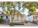 Inviting single-story home featuring a cozy front porch, tidy landscaping, and a welcoming front entrance at 5 Addison St, Charleston, SC 29403