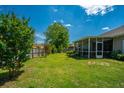 Large backyard featuring a well-maintained lawn, mature trees, and a screened-in porch for relaxation at 5008 Bowles Dr, Summerville, SC 29485