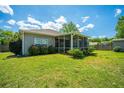 Expansive backyard with lush green grass, mature trees, and a screened-in porch, perfect for outdoor living at 5008 Bowles Dr, Summerville, SC 29485