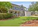 Charming two-story home with a well-manicured lawn, inviting front porch and attached two car garage at 5401 Diston Court, North Charleston, SC 29420