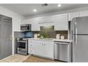 Modern kitchen featuring stainless steel appliances, white cabinets, and stylish backsplash at 5817 Canterbury Dr, Hanahan, SC 29410