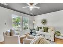 Bright living room featuring hardwood floors, white furnishings, and two large windows at 5817 Canterbury Dr, Hanahan, SC 29410