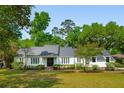 Charming one-story home with a manicured lawn, set amongst mature trees for added privacy at 667 Shortwood St, Charleston, SC 29412