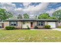 Inviting single-story brick home with a manicured lawn, updated paint and shutters, and attached garage at 7655 Ovaldale Dr, North Charleston, SC 29418