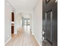 Hallway with views of the kitchen and other rooms, all featuring neutral paint and wood flooring at 1007 Halfacre Ln, Ladson, SC 29456