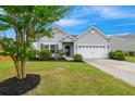 Attractive single-story home with a manicured lawn, beautiful landscaping, and an attached two-car garage at 1007 Halfacre Ln, Ladson, SC 29456