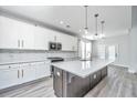 Modern kitchen with stainless appliances, white cabinets, and a large island with stone countertops at 101 Firebrick Way, Summerville, SC 29483