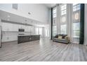 Bright living room with soaring ceilings, large windows, and an open floor plan to the modern kitchen at 101 Firebrick Way, Summerville, SC 29483