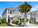 Charming home featuring a palm tree, lush landscaping, an American flag, and a welcoming front entrance at 1052 Sago Palm Ct, Mount Pleasant, SC 29429