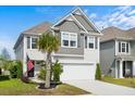 Inviting two-story home with a two-car garage, palm tree, and an American flag waving in the breeze at 1052 Sago Palm Ct, Mount Pleasant, SC 29429