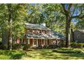 Beautifully landscaped two-story brick home with lush green trees surrounding the property at 112 Huckleberry Ln, Summerville, SC 29485