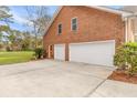 A spacious three-car garage with ample parking space and a red brick exterior is on display at 1164 Out Of Bounds Dr, Summerville, SC 29485