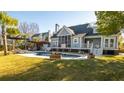 Spacious backyard featuring a refreshing private pool with lush green grass, palm trees, and an outdoor lounge area at 122 Lucia St, Charleston, SC 29492