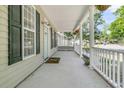 Spacious front porch with classic white railings, offering a relaxing outdoor space and neighborhood views at 1429 Swamp Fox Ln, Charleston, SC 29412