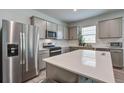 Modern kitchen with stainless steel appliances, a large island, and gray cabinets at 143 West Bradford Pointe Dr, Summerville, SC 29486