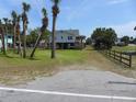 Coastal home with palm trees, a spacious yard, and classic beach charm at 1603 Lybrand St, Edisto Island, SC 29438
