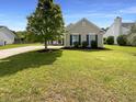 Inviting one-story home displaying a lush green lawn, a mature tree, and manicured landscaping at 1622 Pin Oak Cut, Mount Pleasant, SC 29466